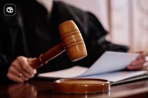 Martelo de juiz sobre uma mesa durante sessão judicial, com documentos ao fundo, representando decisões judiciais, processos e atuação da Justiça.